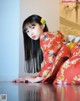 A woman in a red kimono laying on the floor.