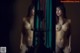 A naked woman standing in front of a mirror.