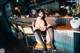 A woman sitting on a stool in a bar.