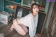 A woman in a white shirt and blue panties posing for a picture.