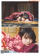 A young girl laying on a bed covered in a blanket.