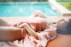 A woman laying on a bed next to a swimming pool.