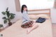 A woman sitting on a bed in a school uniform.