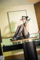 A woman sitting on top of a desk in a room.