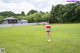 A woman in a bikini holding a soccer ball in a field.